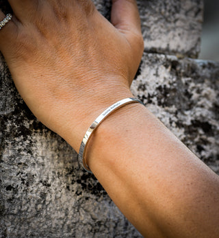 L'Iconica bangle bracelet in steel, "Buona Fortuna" engraving on the outside